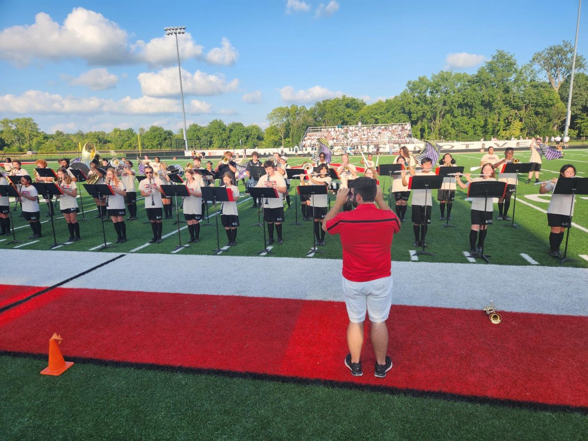 Mr. Zehr directs the Marching Highlanders during a football game.