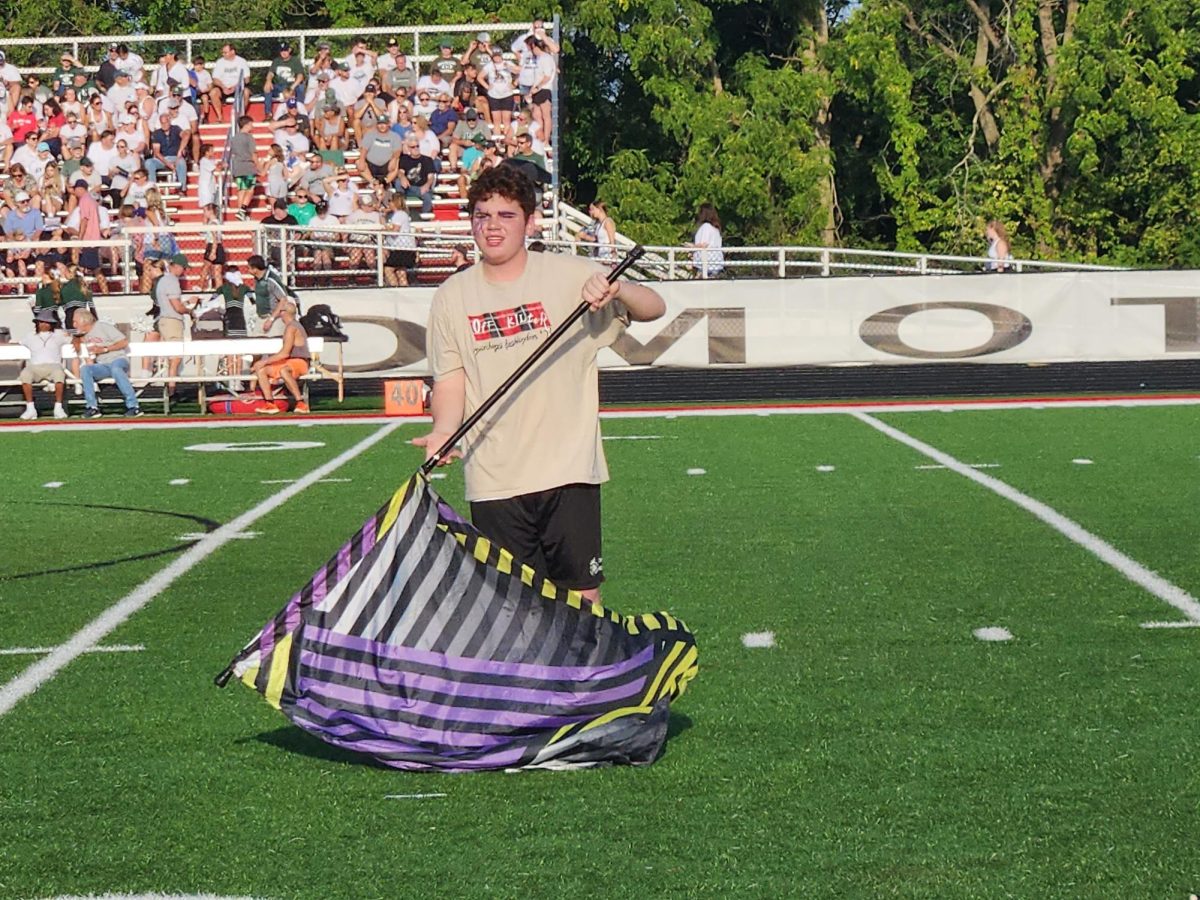 Senior Dylan Goode twirls the flag at at football game.