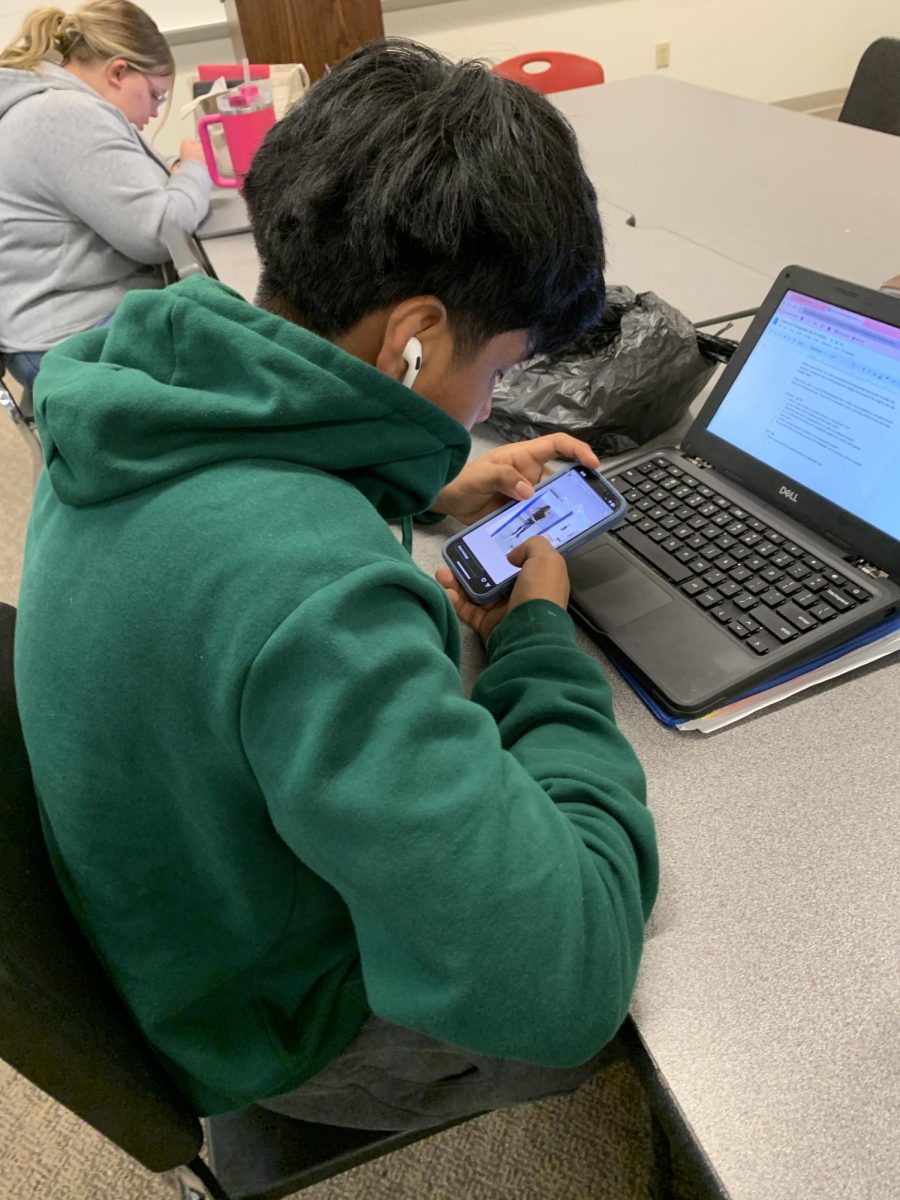 Freshman Eric Rosas Santiago uses his phone in class.
