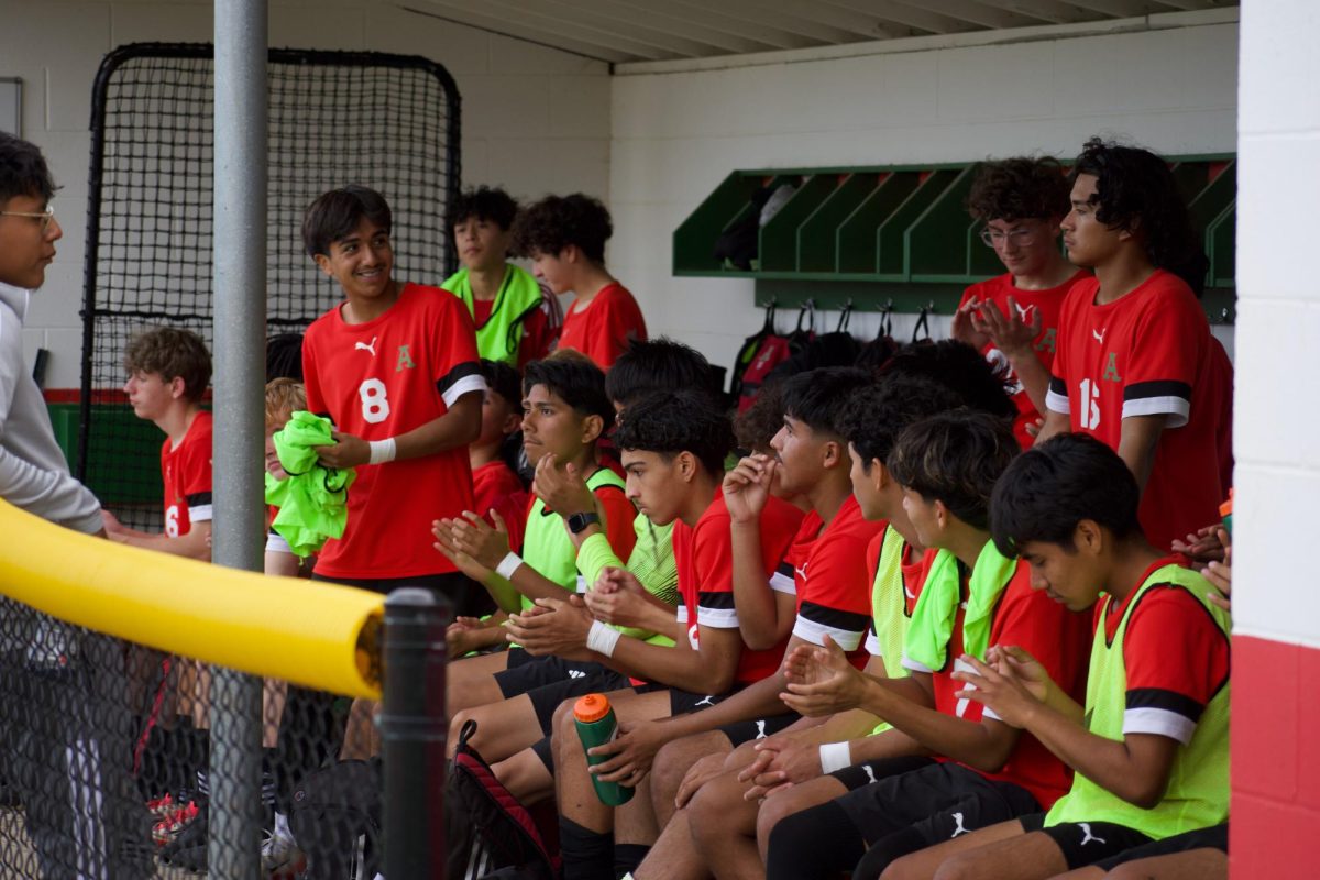 The boys soccer team shares a moment in the baseball dugout.