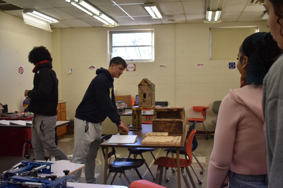 Business students at D26 Career Campus show sophomores few of the things they sell for their class. The business class and the construction class work together to sell items that they build.